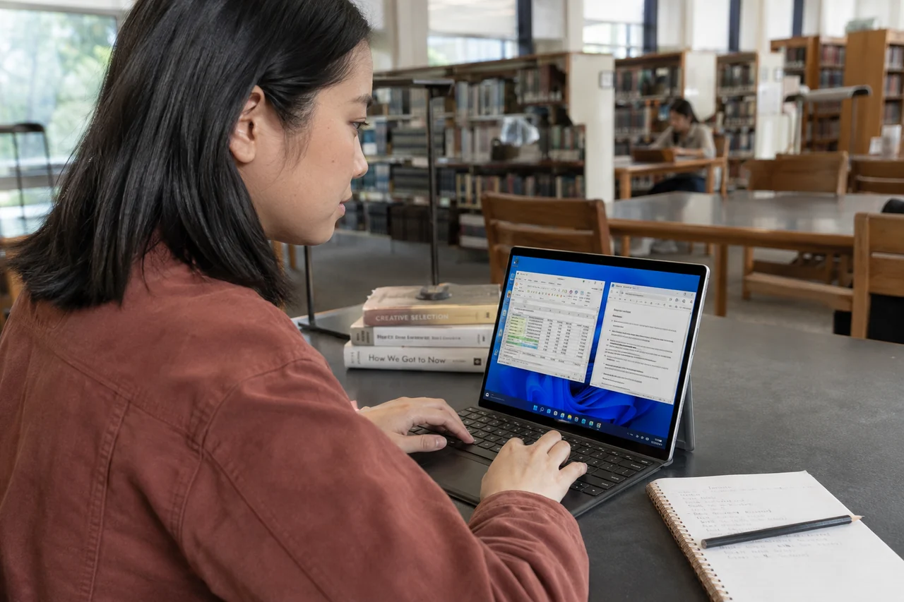 A woman working in Windows on a tablet in a library